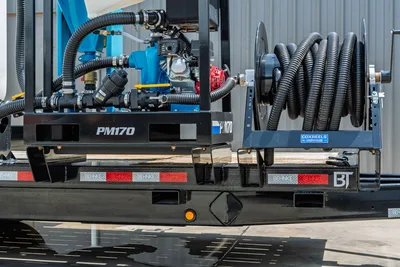 Behnke TBCT2220ET-BT-R trailer rear view showing PM170 mud mixer, hydraulic plumbing, and Coxreels hose reel with corrugated hose