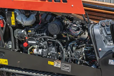 2021 Ditch Witch JT20 engine compartment view showing 74hp motor, hydraulic pumps, wiring harness, and track assembly.