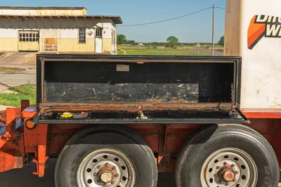 Belshe WB14-2EP trailer, side view, open toolbox, dual axles, rust, Ditch Witch logo visible.