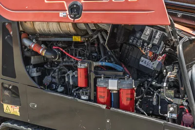 2018 Ditch Witch JT30 All Terrain engine compartment open, showing hydraulic filters, fuel filters, wiring harness, and fluid lines