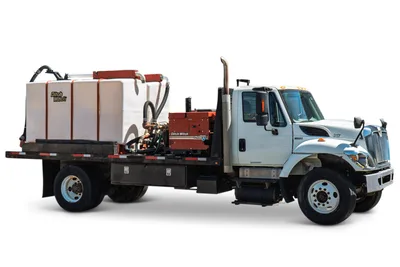 2015 International 7400 mud truck, driver-side view, Ditch Witch FM25 mixing unit, large white poly tank, flatbed, toolboxes, exhaust stack