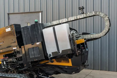 2016 Vermeer D23x30 S3 drill carriage close-up showing fluid tanks, hydraulic hose carrier chain, and yellow frame
