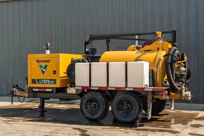 2024 Vermeer LP573SGT vacuum excavator side view, trailer-mounted, featuring slurry tank, intake hoses, and fresh water tanks.