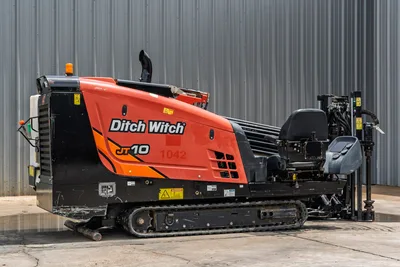 2018 Ditch Witch JT10 HDD drill, driver-side view, orange hood, rubber tracks, drill pipe rack, operator console visible