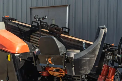 2020 Ditch Witch JT24 operator station, rear view showing seat, drill pipe rack, joystick controls, and engine compartment.